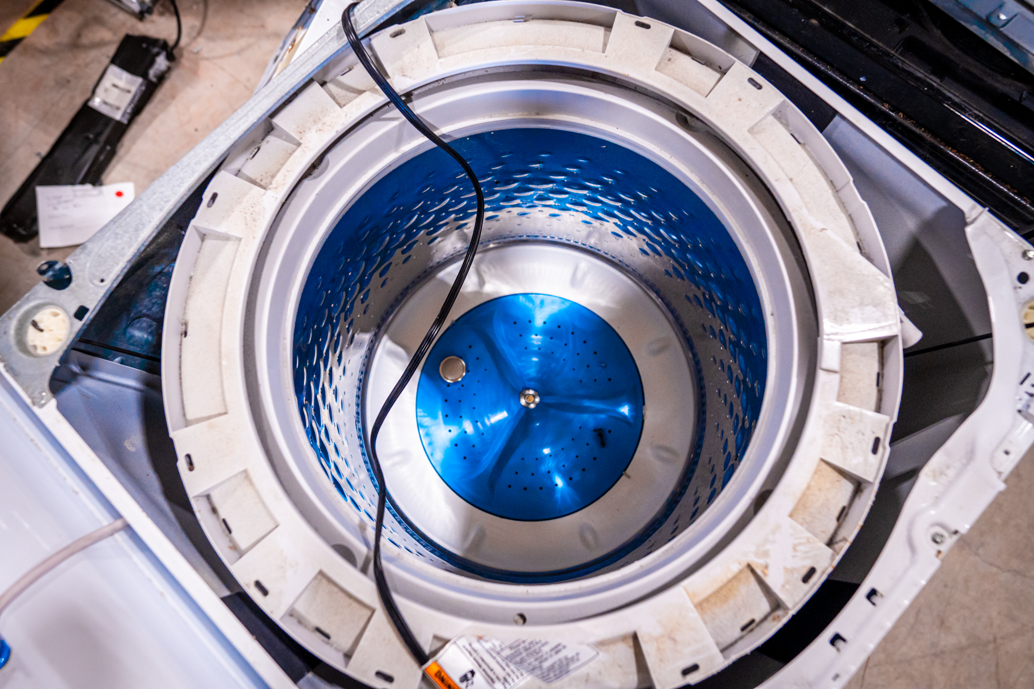 A technician working on the control panel of a GE washer.