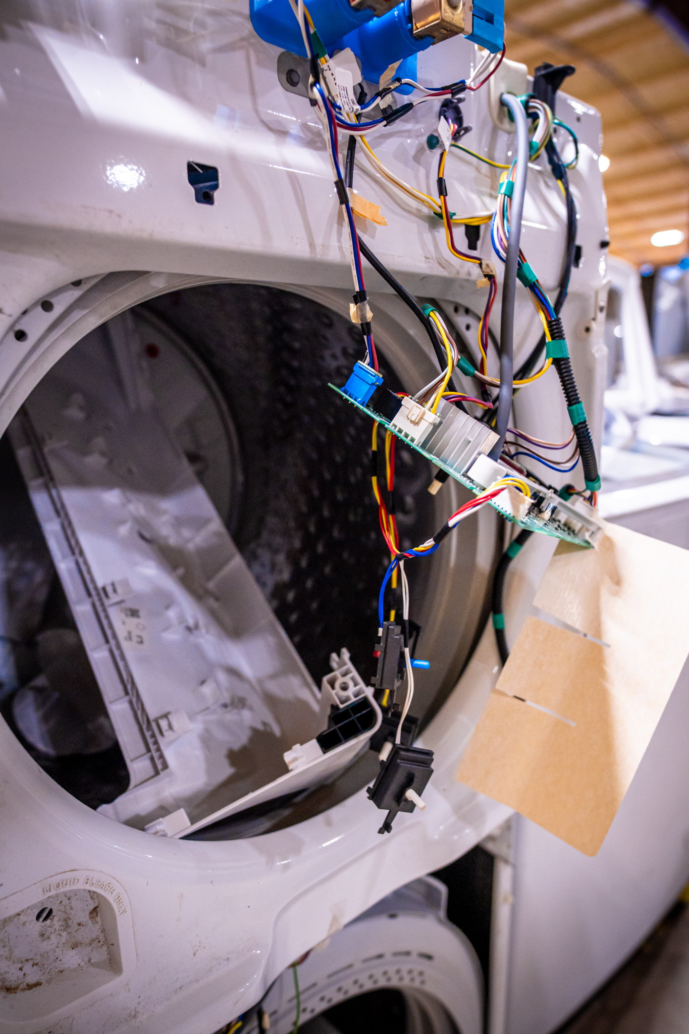 A technician examining the internal belt of a washing machine.