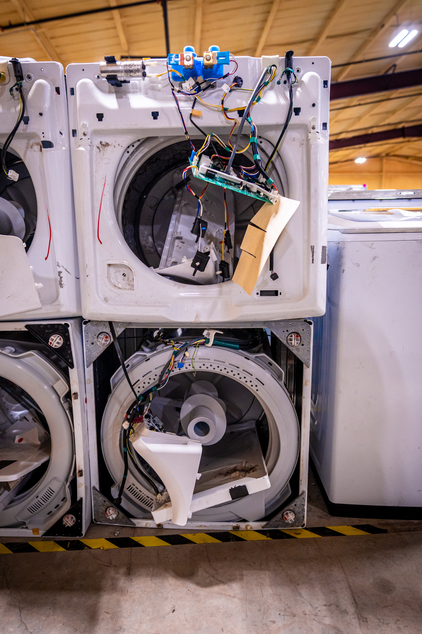 A technician checking the drain hose of a washing machine.