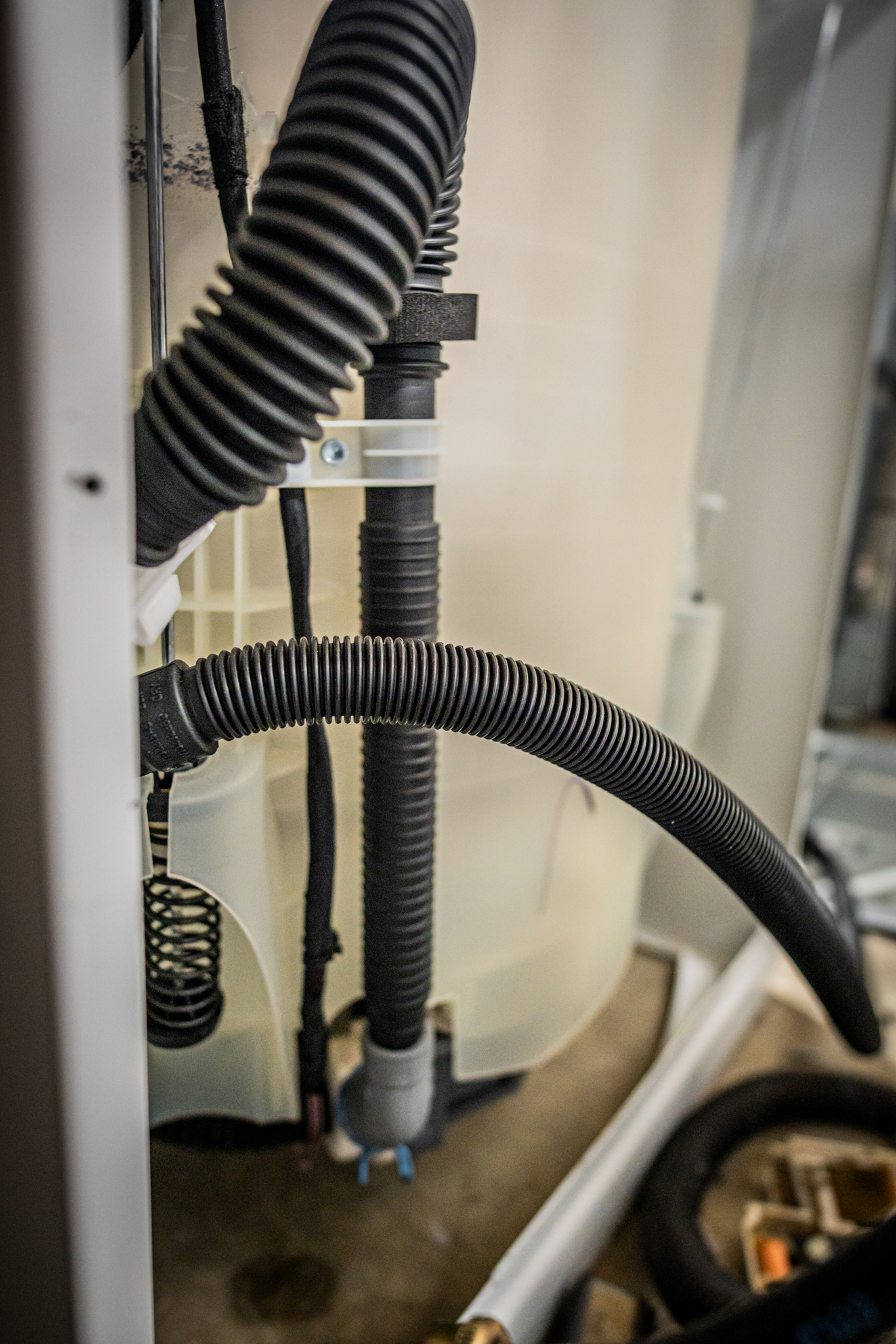 A technician examining the internal components of a GE washer.