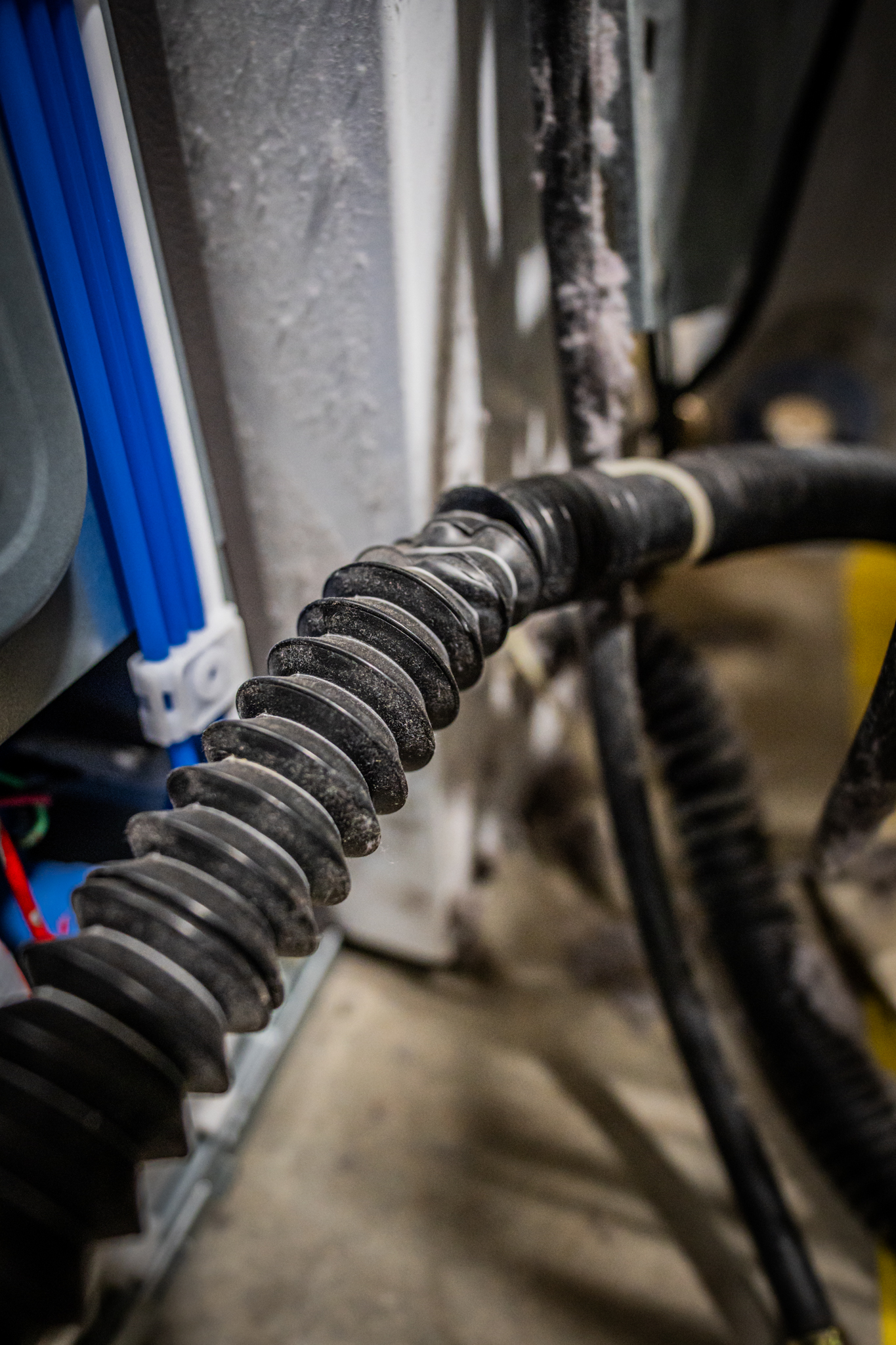 A technician inspecting the drain pump and filter area of a GE washer