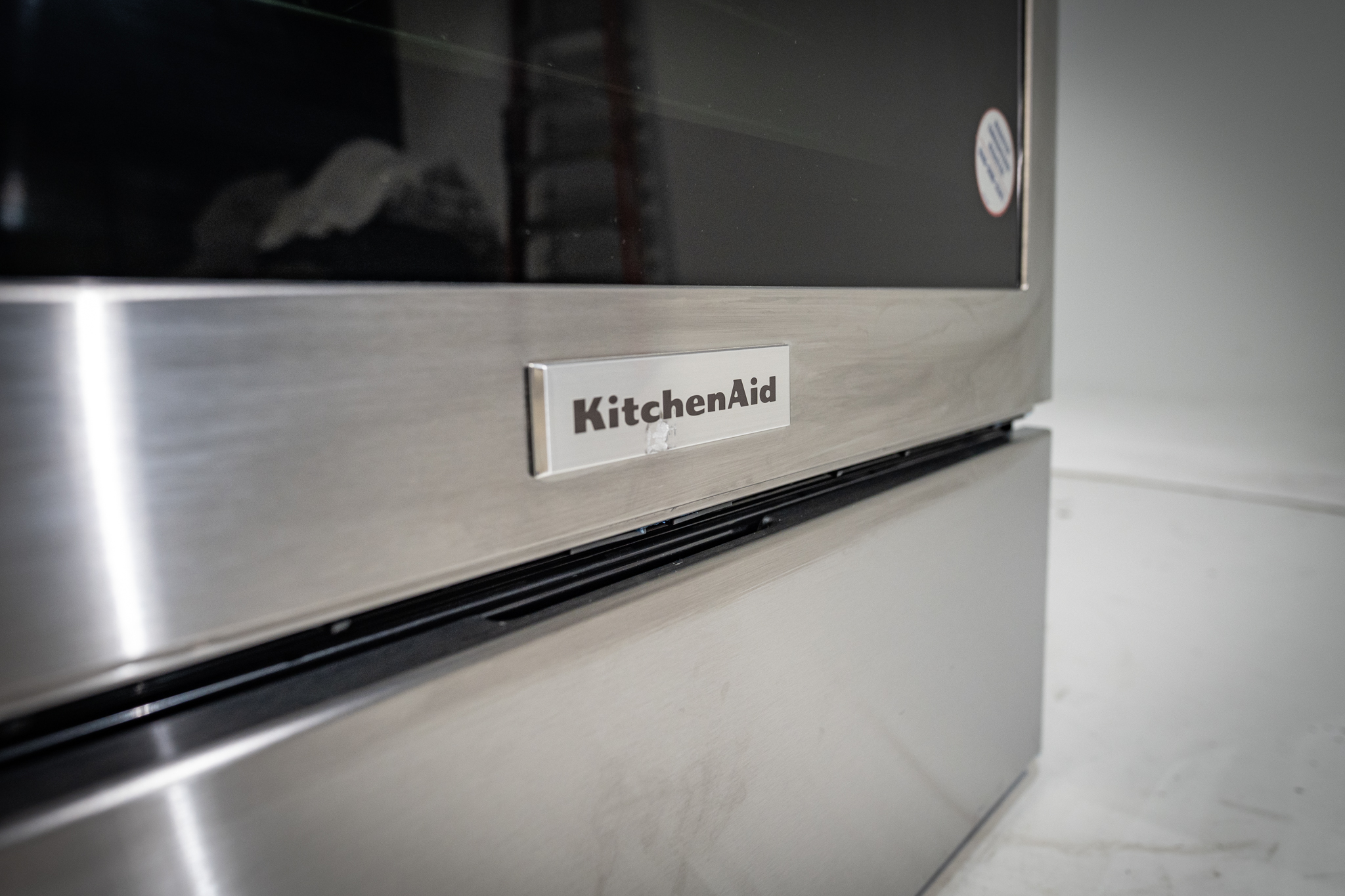 NEU Appliance Repair technician showing the difference between a warming drawer and storage drawer in an Austin-area home